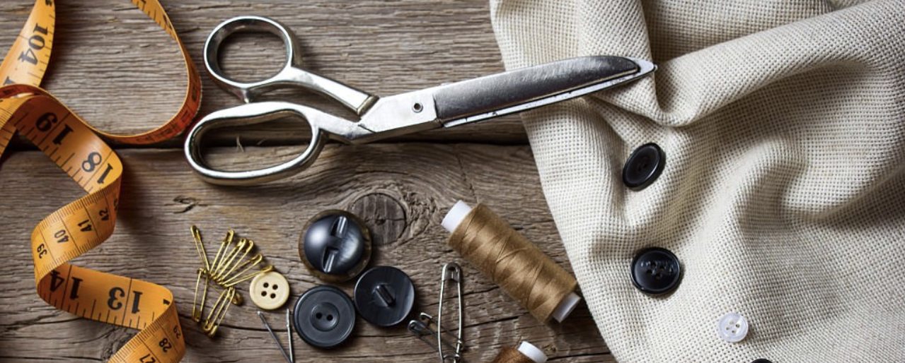 Tailor&rsquo;s scissors resting on a measuring tape
